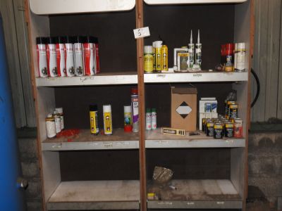 de nombreux pots de peinture sur les étagères du garage