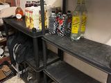 a black shelf with bottles and cans on it in a room