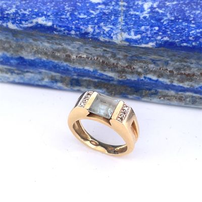 une image représentant une bague en or sertie de deux diamants sur une pierre bleue