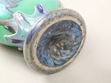 a green vase with a blue swirl inside of it