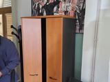 un homme debout à côté d'une armoire dans une pièce