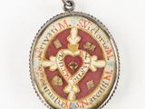 a picture of a pendant with a cross and a heart on it