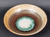 a brown and green bowl with a blue center