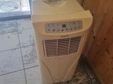 a small air conditioner sitting in the corner of a room