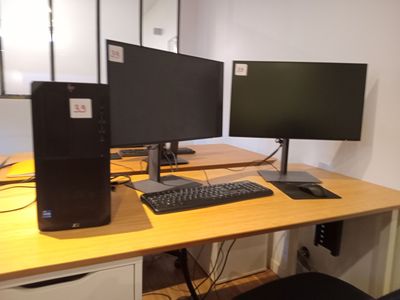 deux écrans d'ordinateur et un clavier sur un bureau