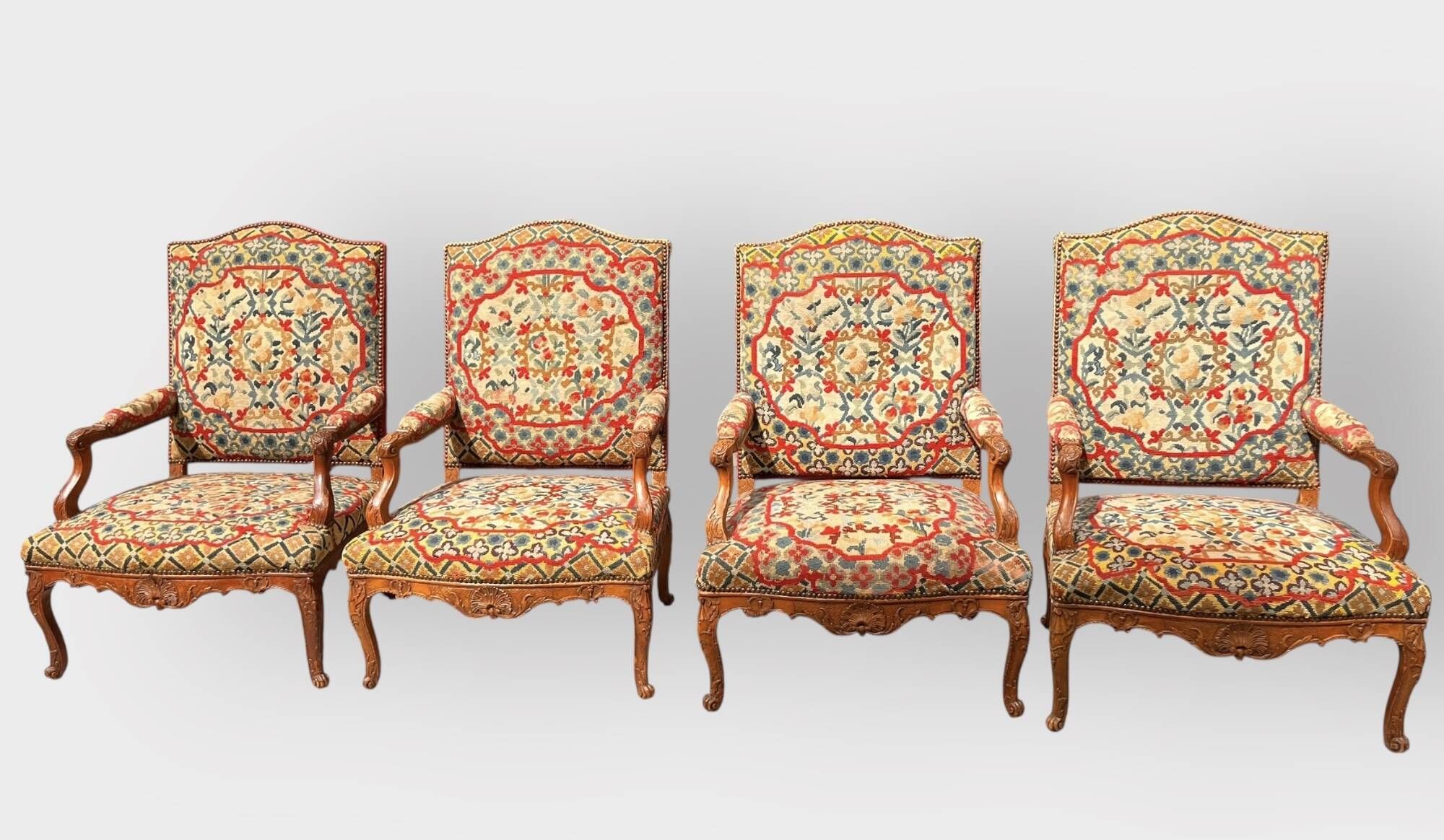 Suite de 4 larges fauteuils à haut dossier à la reine en noyer mouluré et sculpté à décor de coquilles et de feuilles...