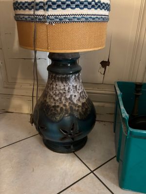 a lamp that is sitting on the floor next to a trash can