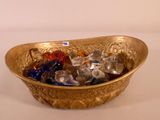 a gold bowl filled with crystal stones on a white table