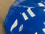 a close up of a blue car parked in a parking lot
