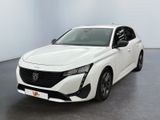 La voiture blanche est garée dans une grande pièce au sol noir