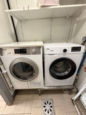 two washers and a dryer in a small room