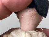 a person holding a small doll in their hand