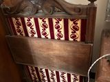 un lit en bois recouvert d'une couverture rouge et blanche