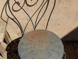 a metal chair that is sitting outside on the sidewalk