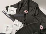 black bucketer hat with tags on it sitting on a white surface