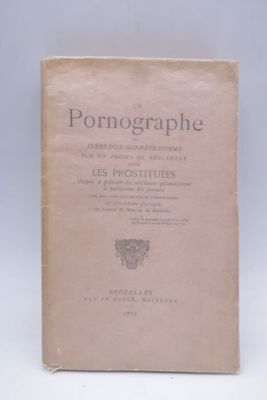 un vieux livre posé sur une table à côté d'un mur blanc