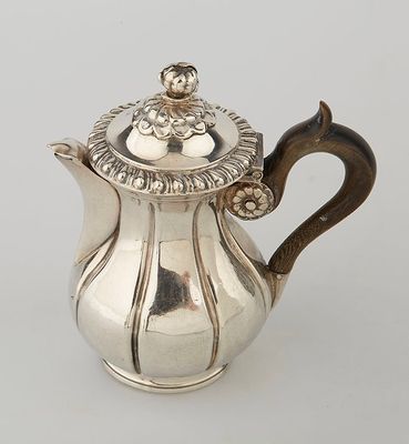 a silver tea pot with a lid and a handle