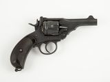un gros plan d'un revolver posé sur une surface blanche, avec un fond blanc