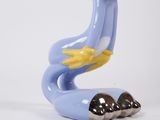 a blue and yellow statue of a bird on a white surface