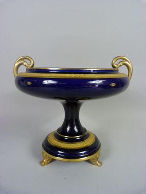 un vase bleu et or posé sur un socle