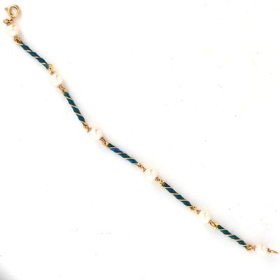un gros plan d'un collier posé sur une surface blanche, avec une chaîne dorée