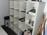 un lit blanc dans une chambre avec une bibliothèque