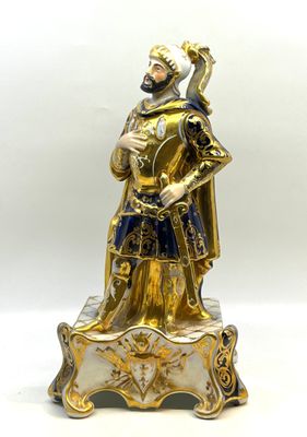 une figurine dorée et bleue représentant un homme en armure