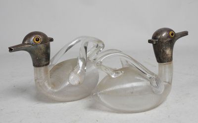 pair of clear glass ducks sitting next to each other on a white surface