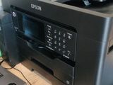 a printer sitting on top of a desk next to a laptop