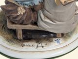 a figurine of a man and a woman sitting on a bench