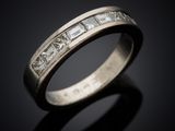 a close up view of a wedding ring with princess cut diamonds