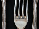 a fork and two spoons on a black table