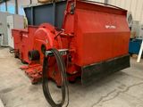 une photo d'une grande machine rouge dans un entrepôt
