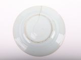 a white plate with a gold rim sitting on a table