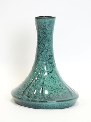 a green vase that is sitting on a white surface