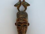 an image of a wooden mask hanging on a wall