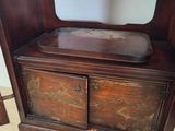 a wooden cabinet with a mirror on top of it