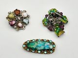 trois broches de formes et de couleurs différentes sur un fond blanc