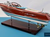 a model of a boat on a stand on a blue surface