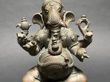 an image of a statue of an elephant sitting on top of a rock