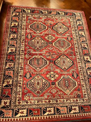 un tapis rouge et noir posé sur un parquet dans une pièce