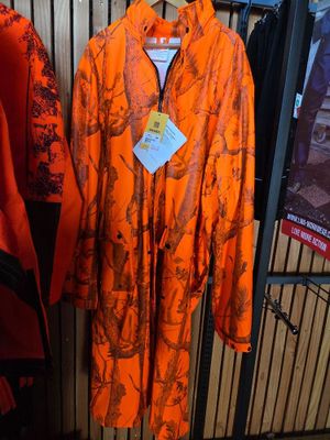 an orange rain coat hanging on a rack in a clothing store