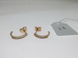deux paires de boucles d'oreilles en or ornées de pierres noires sur un fond blanc