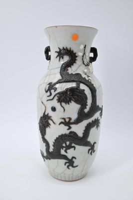 un vase blanc orné de motifs représentant des dragons noirs
