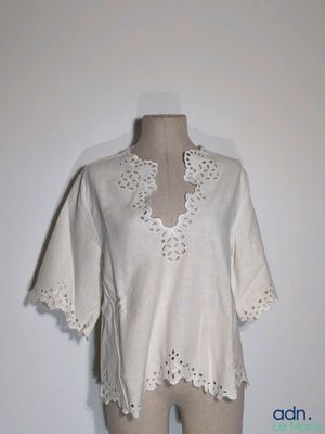 une photo d'un mannequin portant un haut blanc orné de motifs au crochet