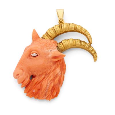 Un pendentif plaqué or représente une tête de chèvre.