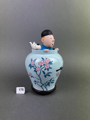 a figurine of a boy sitting in a vase