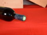 a bottle of wine sitting on a red cloth
