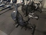 a row of stationary exercise bikes in a gym