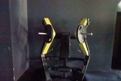 des appareils de fitness jaunes et noirs posés sur un sol noir dans une pièce